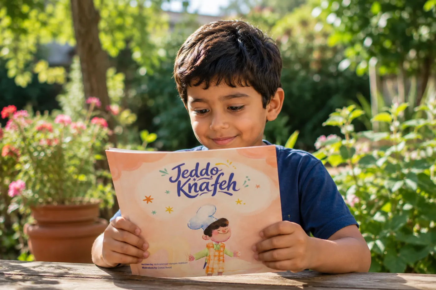 A boy reading the Jeddo Knafeh book in a garden